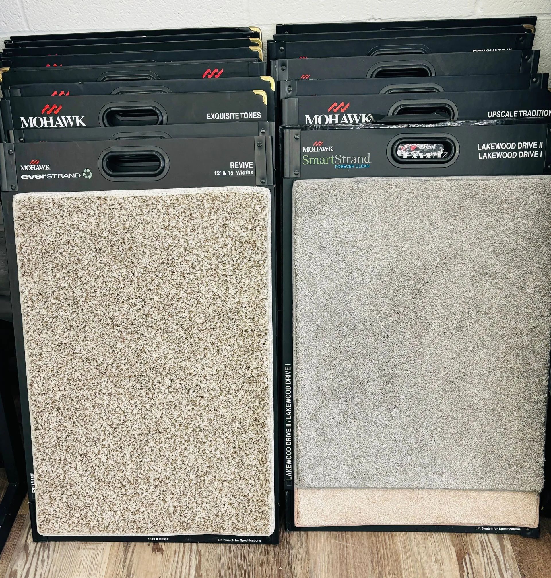 Two carpet sample displays with varying shades of beige and gray. Mohawk brand labels are visible.