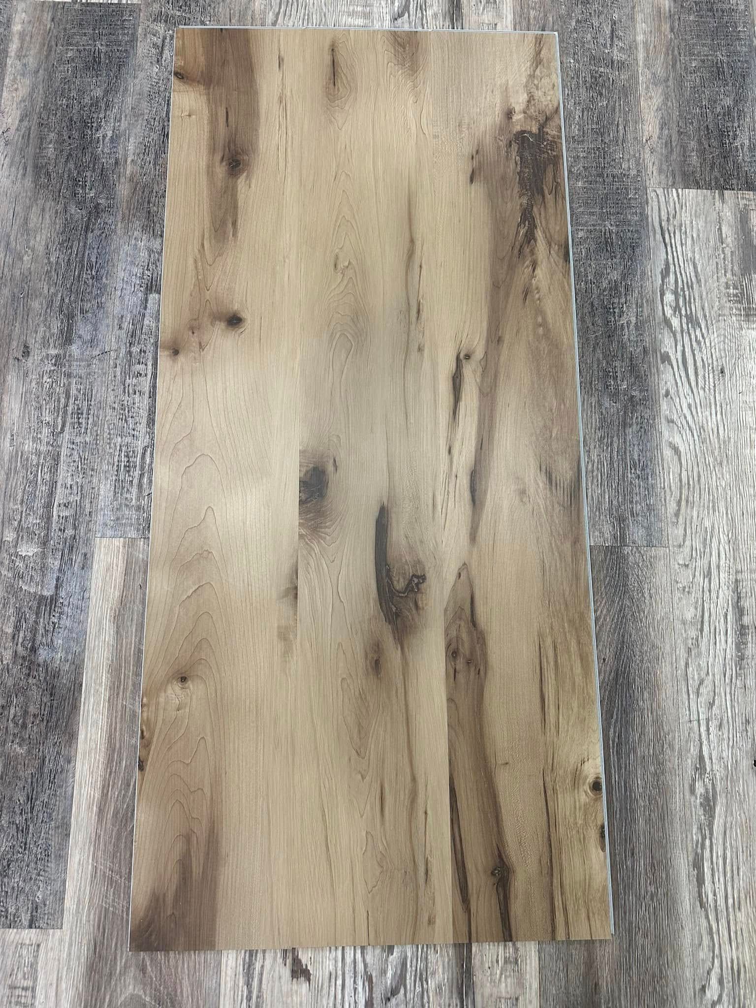 Close-up of a rectangular wood-look plank with varying shades of brown and natural wood grain details.