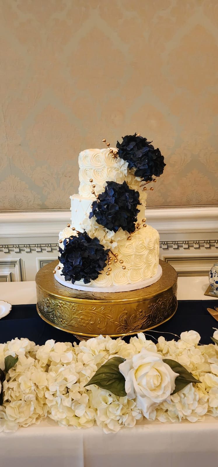 A white and blue wedding cake is sitting on top of a table.