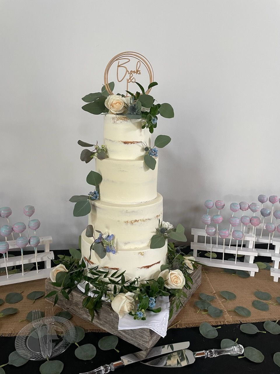 A wedding cake is sitting on top of a wooden table