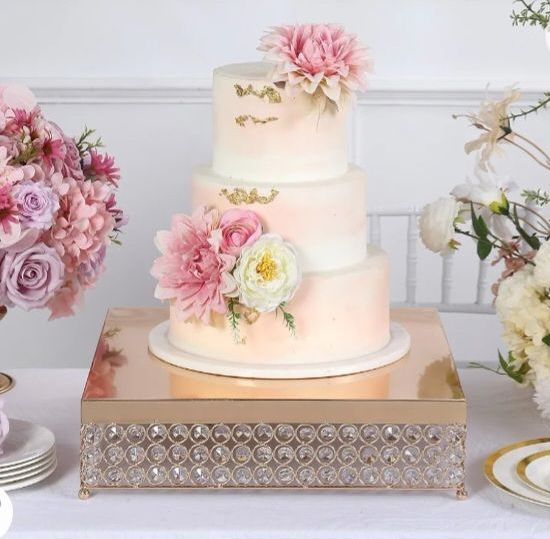 A three tiered cake with pink and white flowers on it