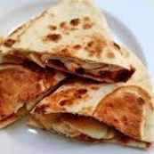 A close up of a quesadilla on a white plate.