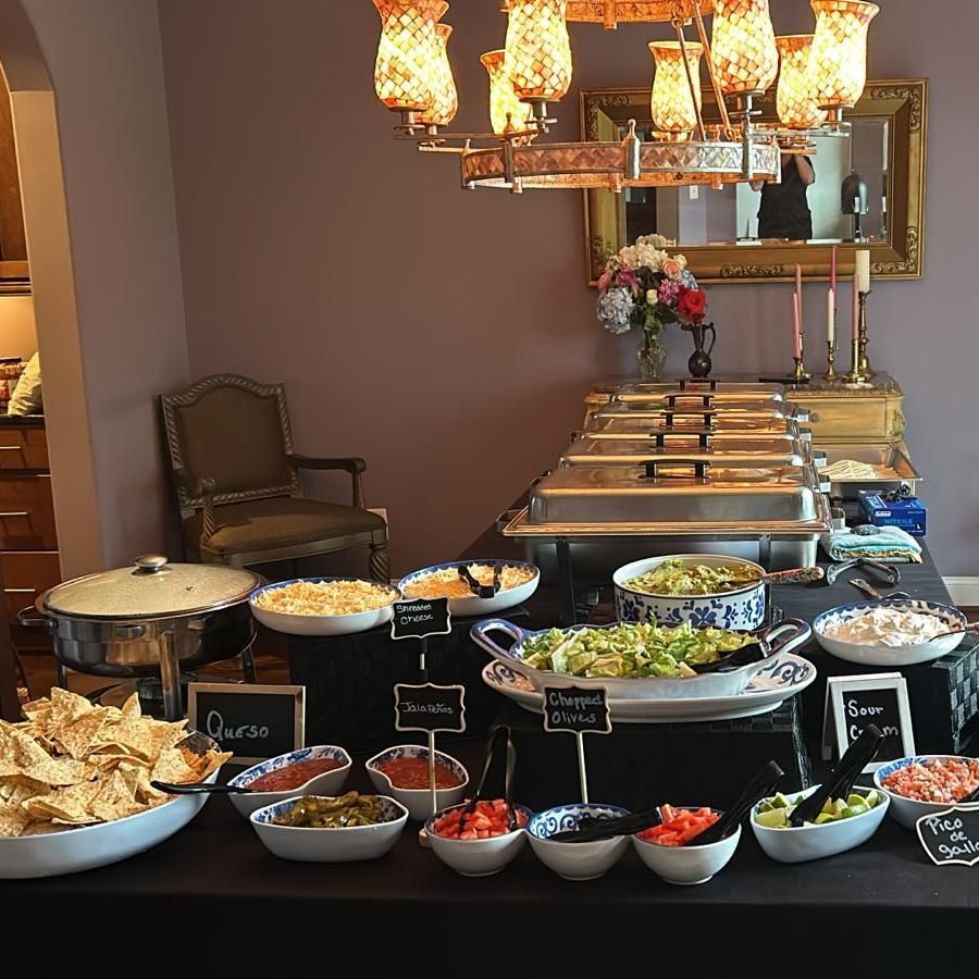 A buffet table with a sign that says queso on it