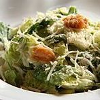 A close up of a salad with lettuce and cheese on a plate.