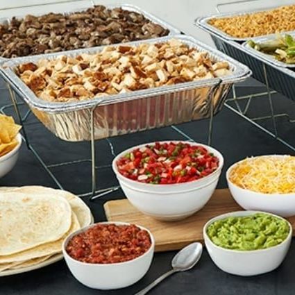 A table topped with bowls of food including guacamole and salsa