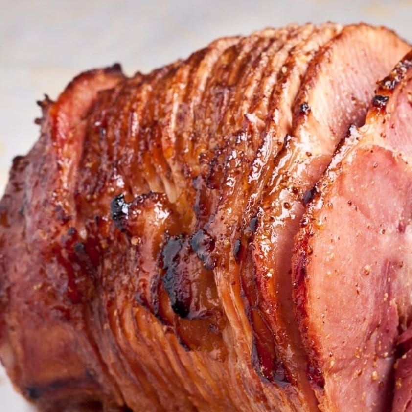 A close up of a piece of ham on a plate.