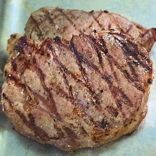 A close up of a grilled steak on a pan