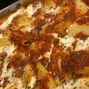 A close up of a casserole dish filled with pasta and sauce.