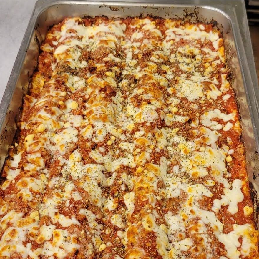 A large casserole dish filled with lasagna and cheese.