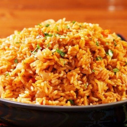 A bowl of rice is sitting on a wooden table.