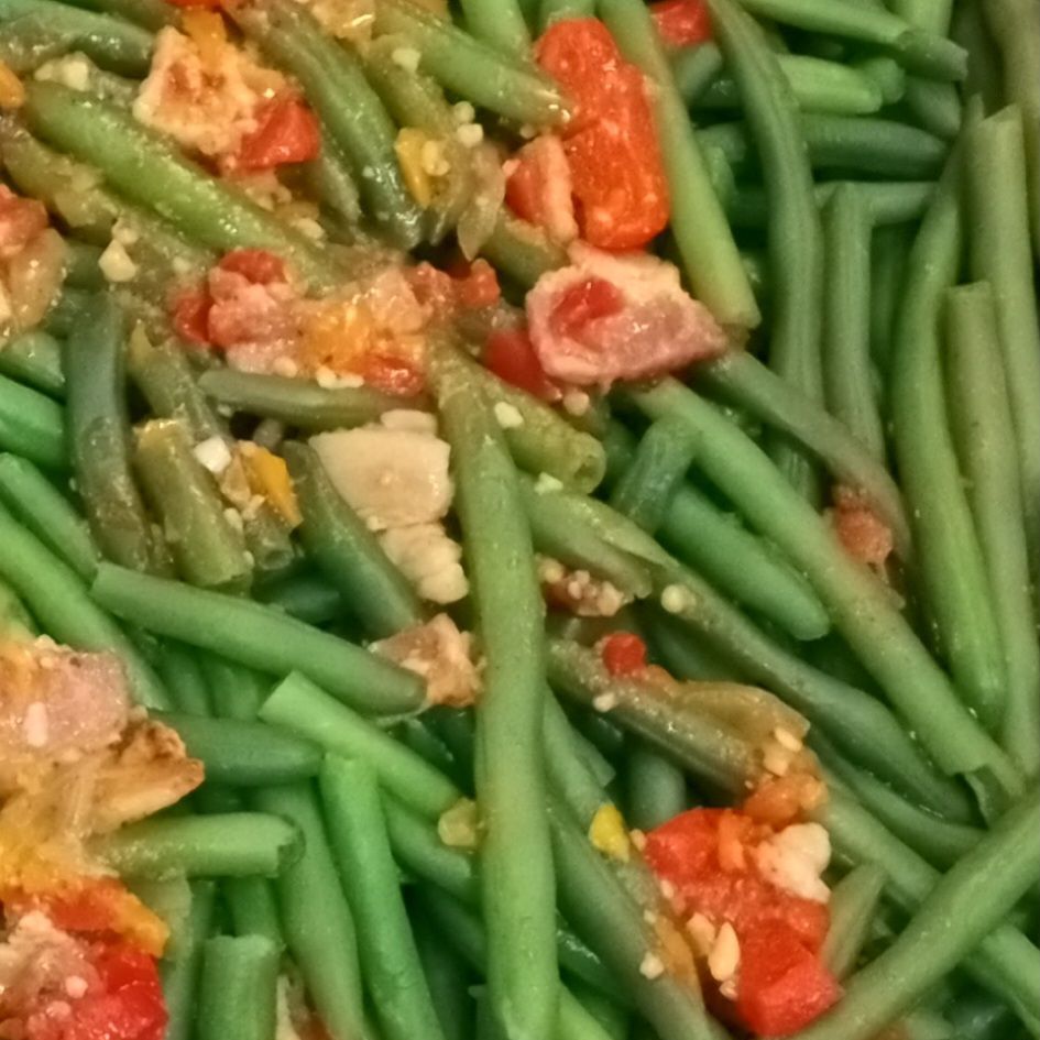 A close up of green beans with tomatoes and other vegetables