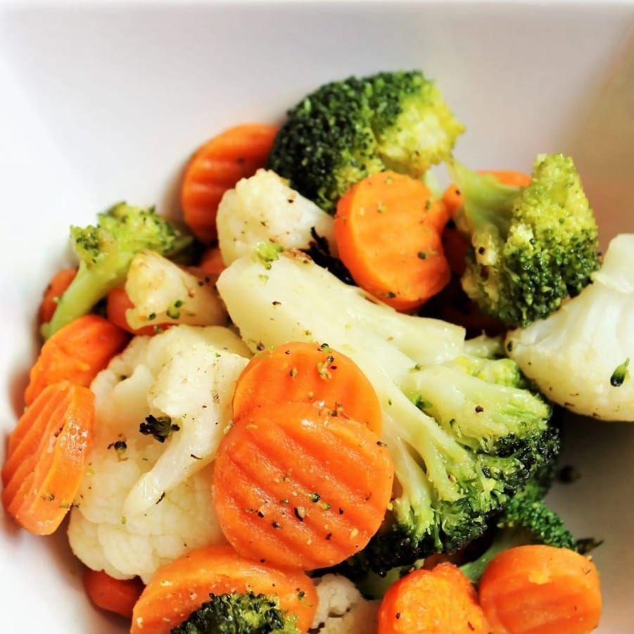 A bowl filled with broccoli carrots and cauliflower