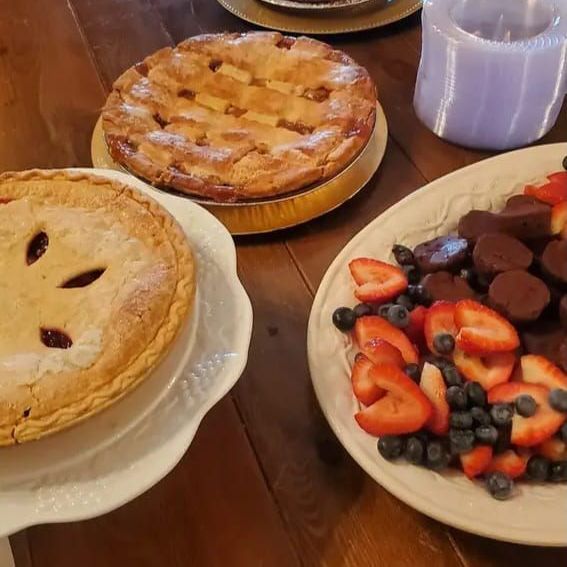 A pie and a plate of fruit are on a table