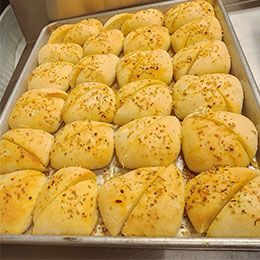 A pan filled with buns and rolls on a table.