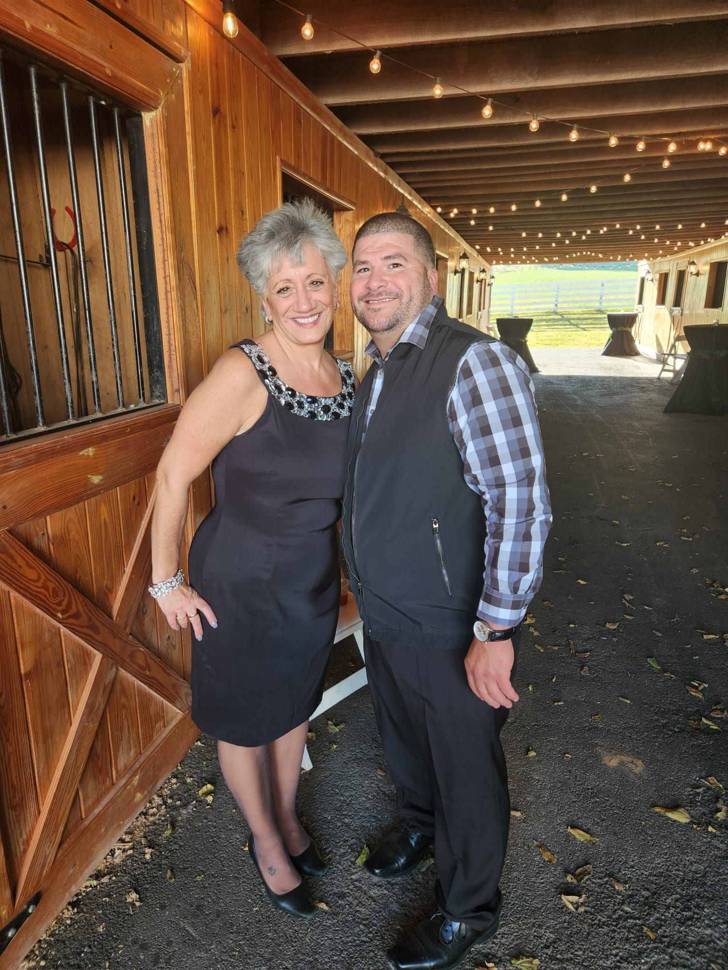 A man and a woman are standing next to each other in front of a wooden building.