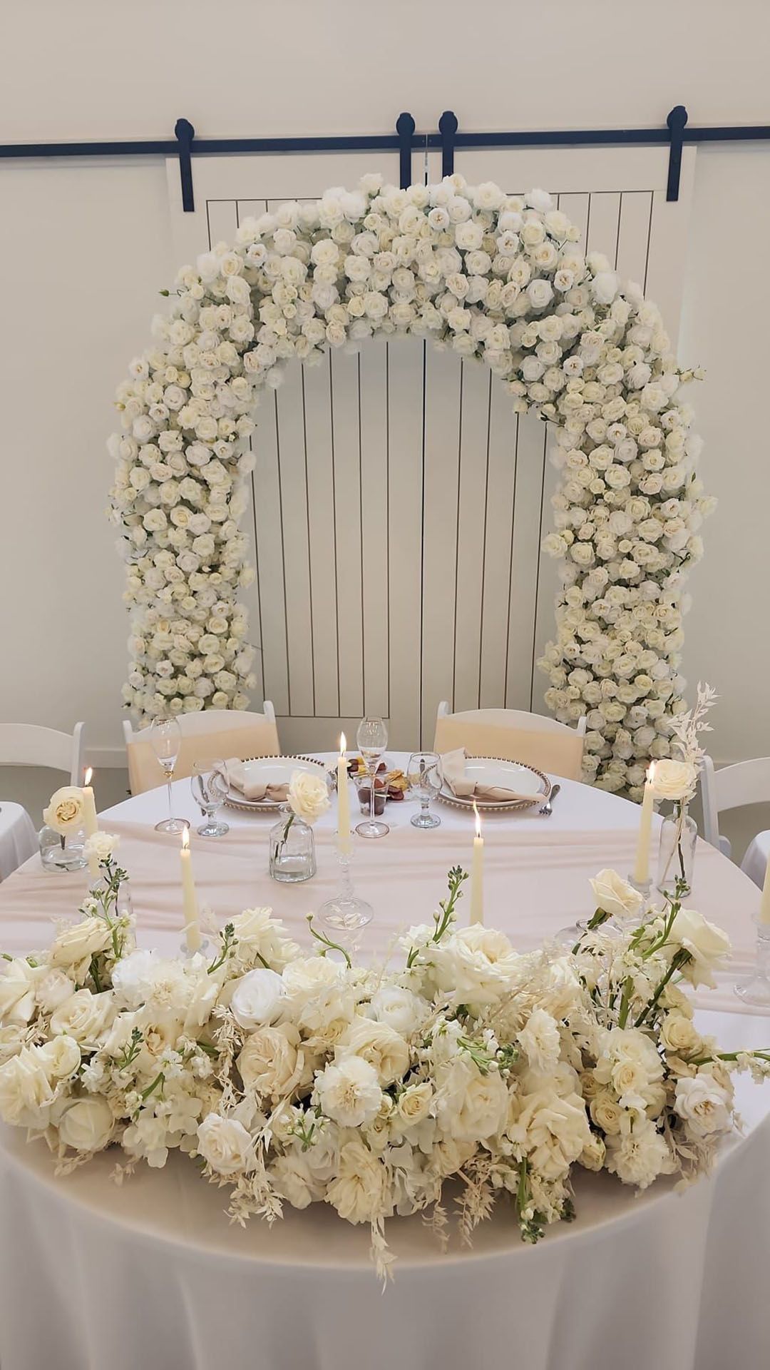 A table decorated with white flowers and candles for a wedding reception