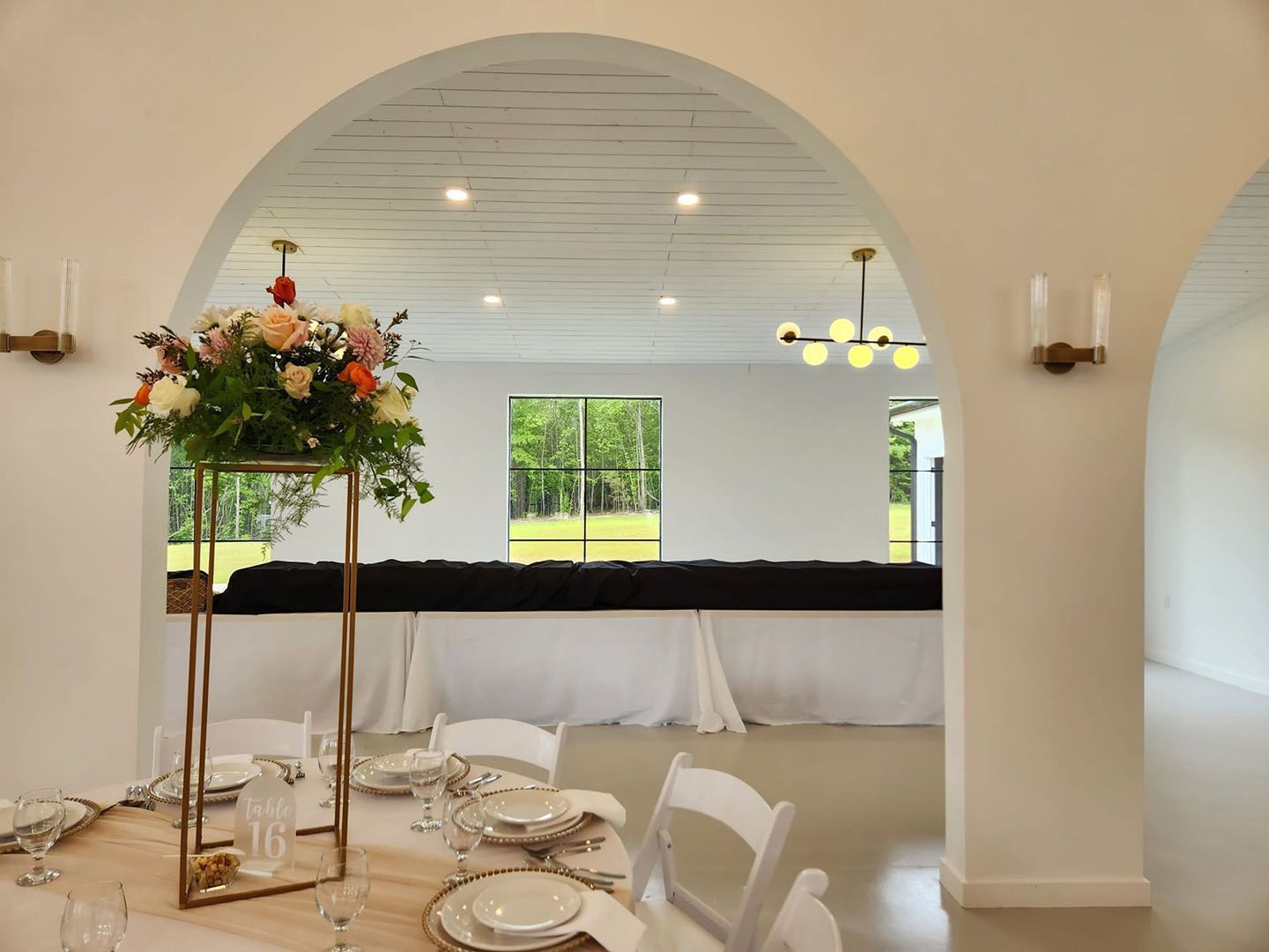 A room with a table and chairs set up for a wedding reception