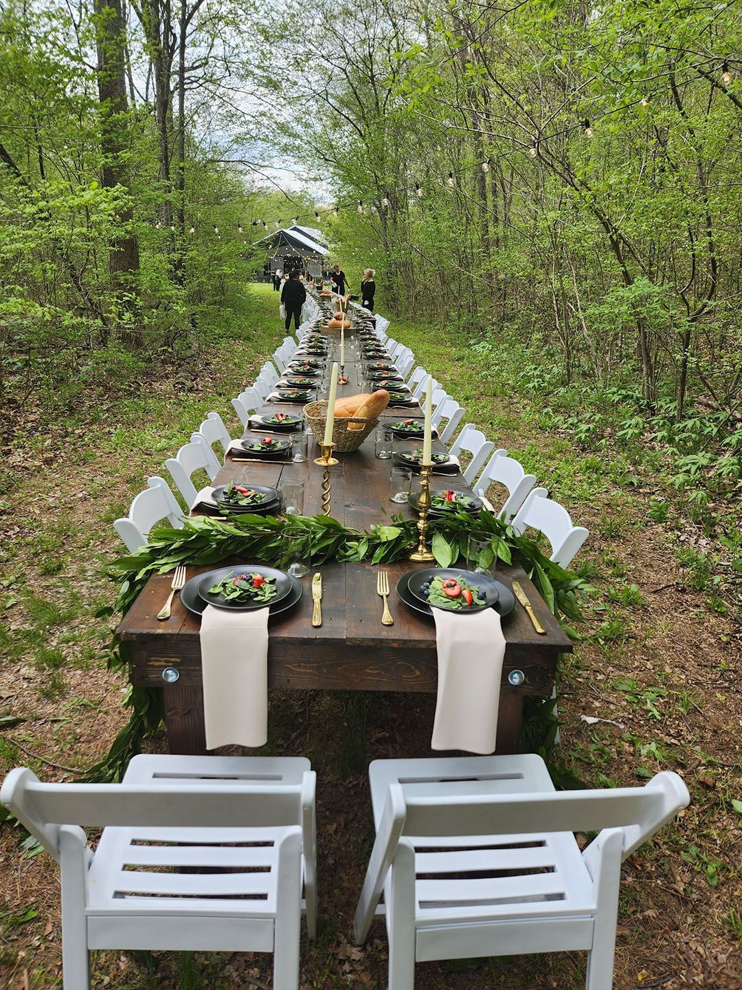 A long table is sitting in the middle of a forest