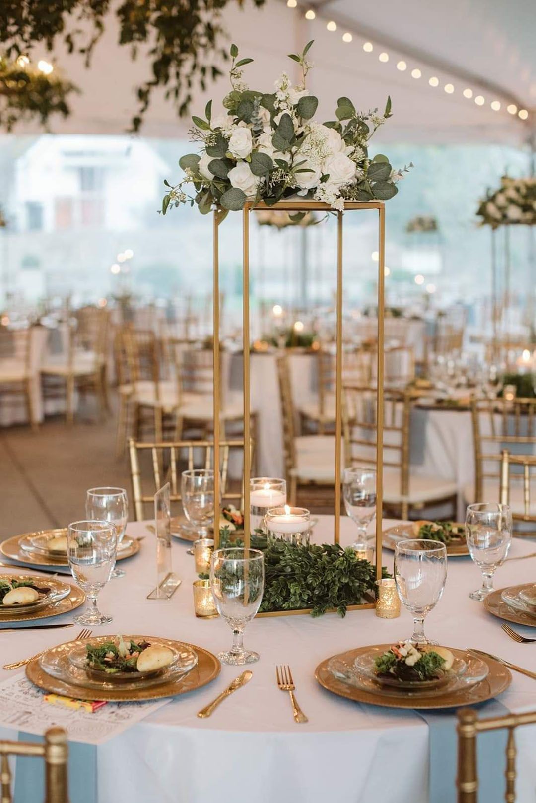 A table set for a wedding reception with plates, glasses, and flowers on it