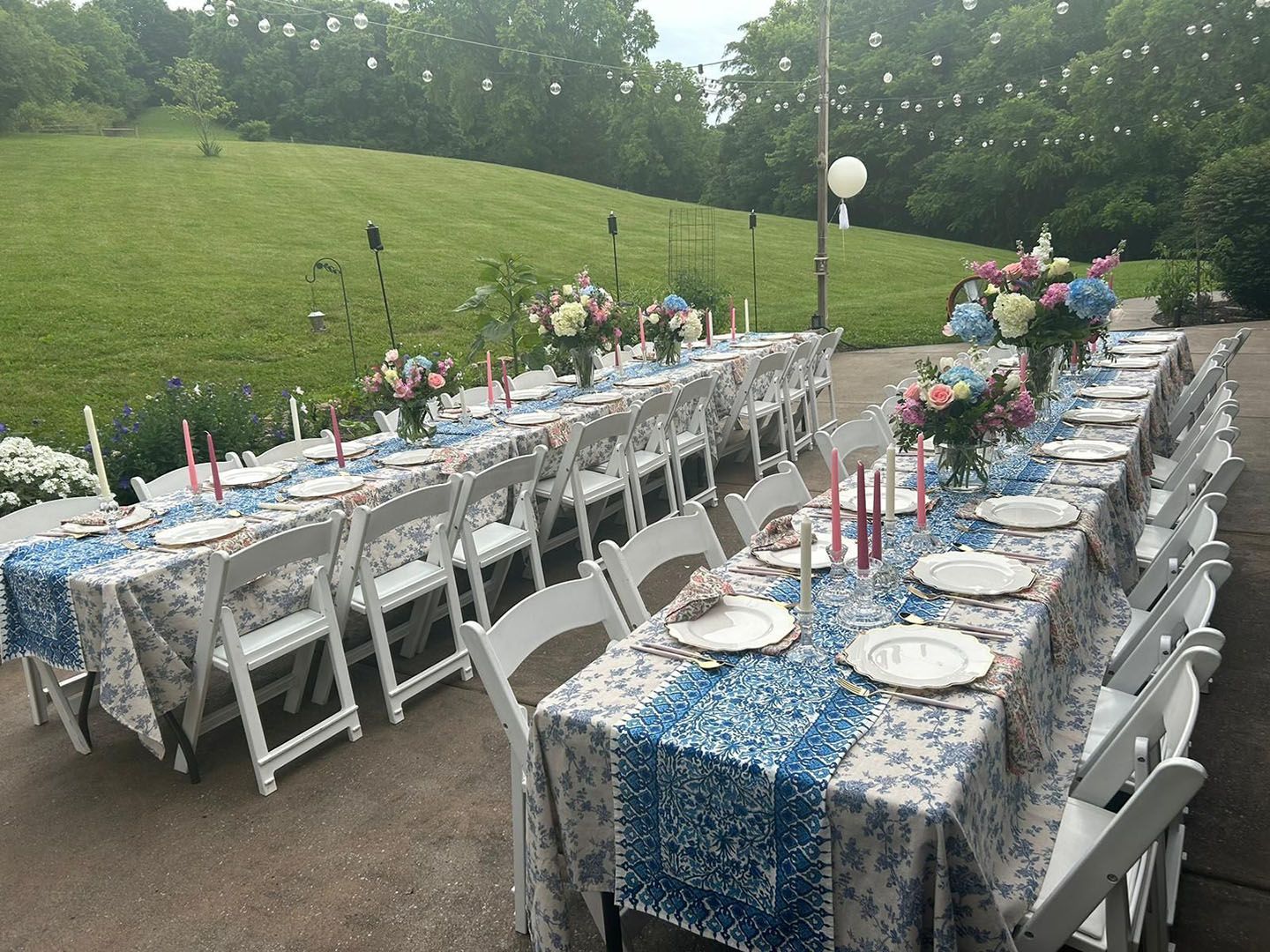 A long table with plates, candles, and flowers on it