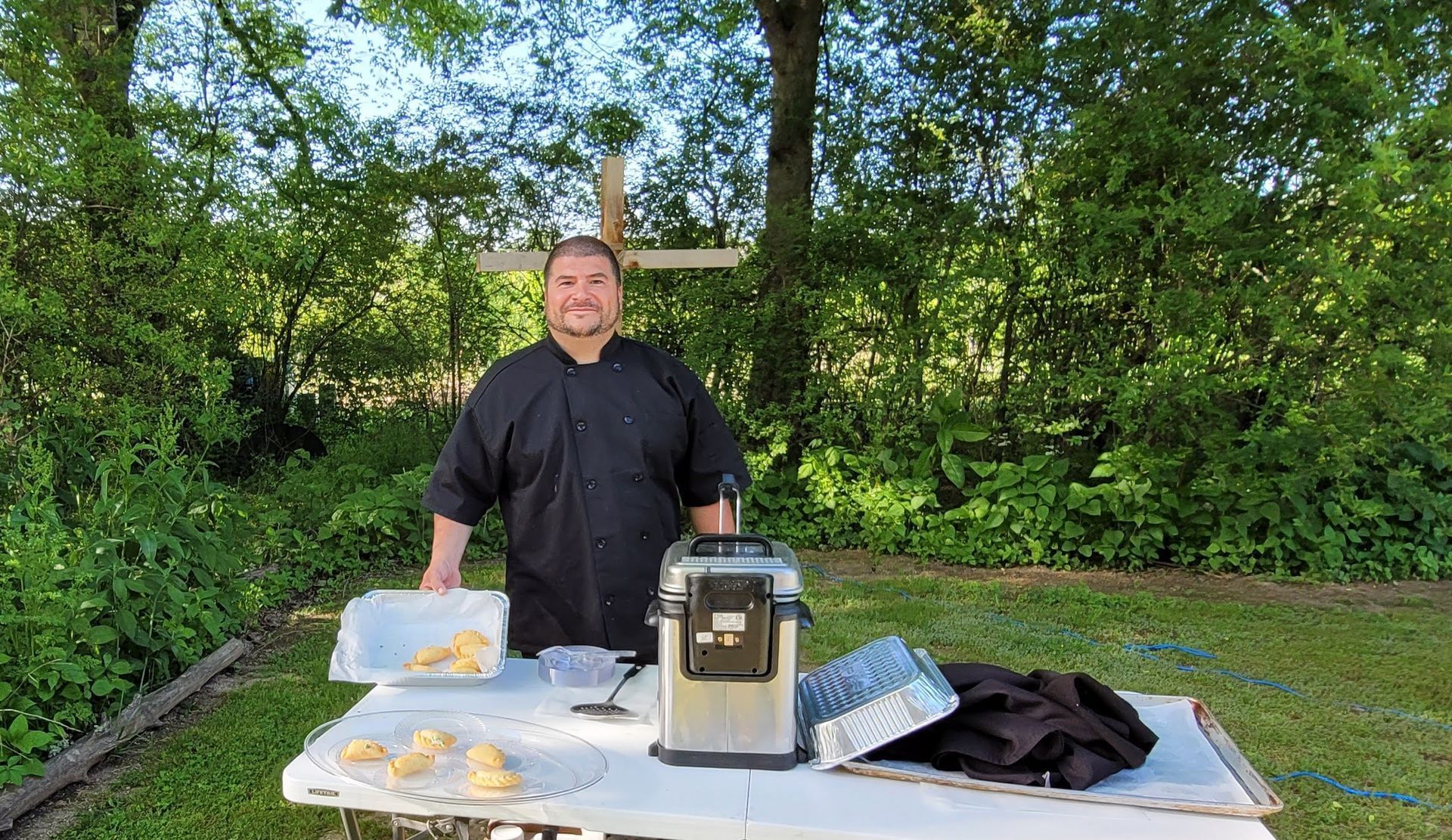A man is standing in front of a table with food on it
