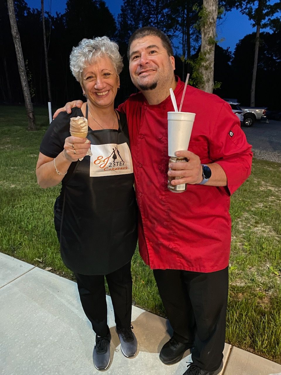 A man and a woman are posing for a picture and the woman is holding an ice cream cone