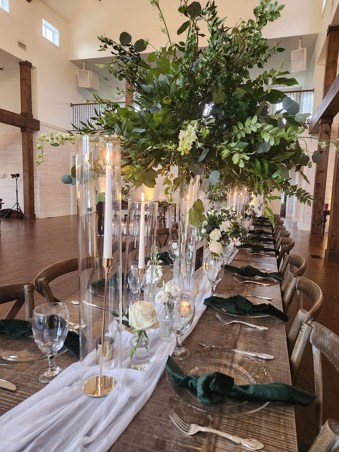 A long table with a vase of flowers and candles on it