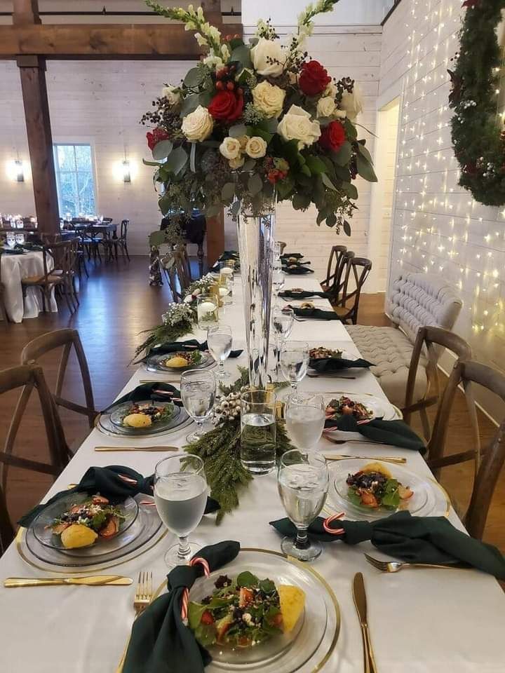 A long table with plates of food and a vase of flowers on it