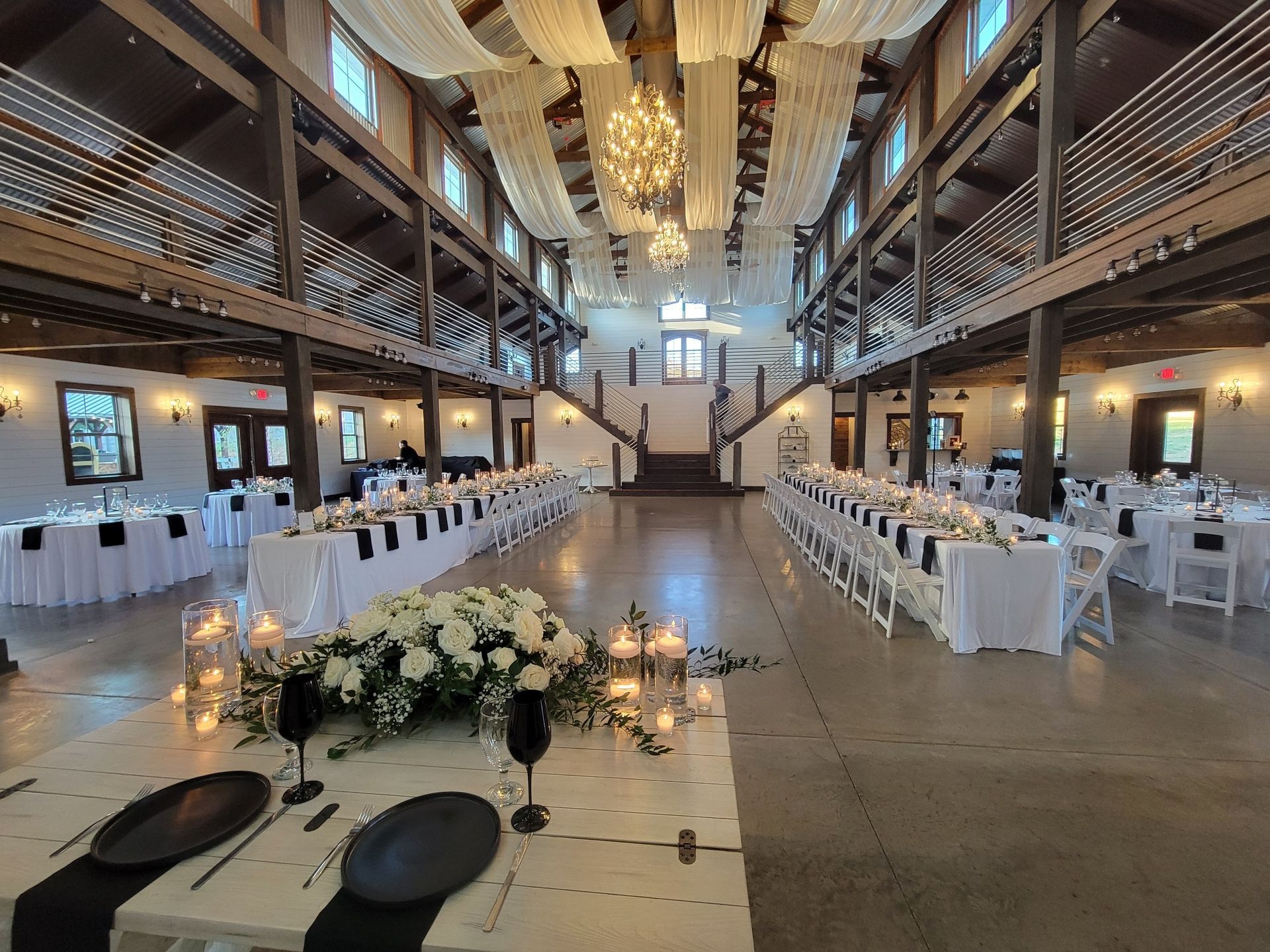 A large room with tables and chairs set up for a wedding reception