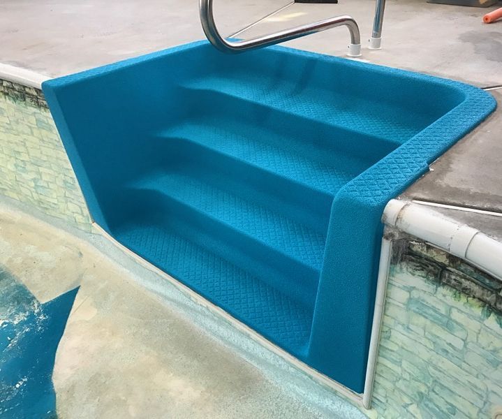 A blue staircase leading to a swimming pool.