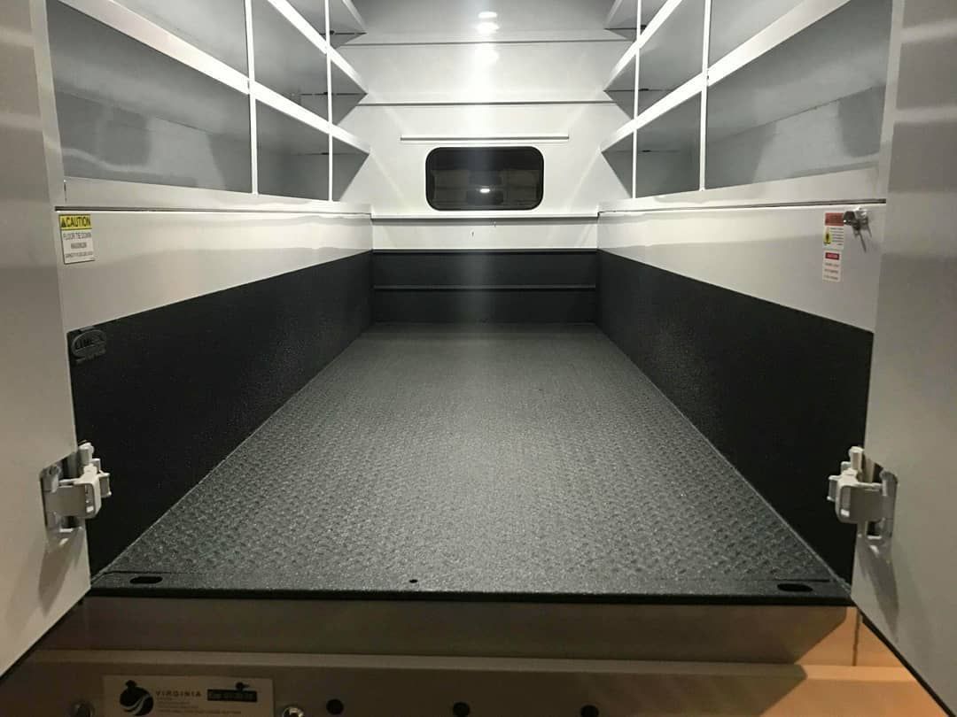 The inside of a van with shelves and a window.