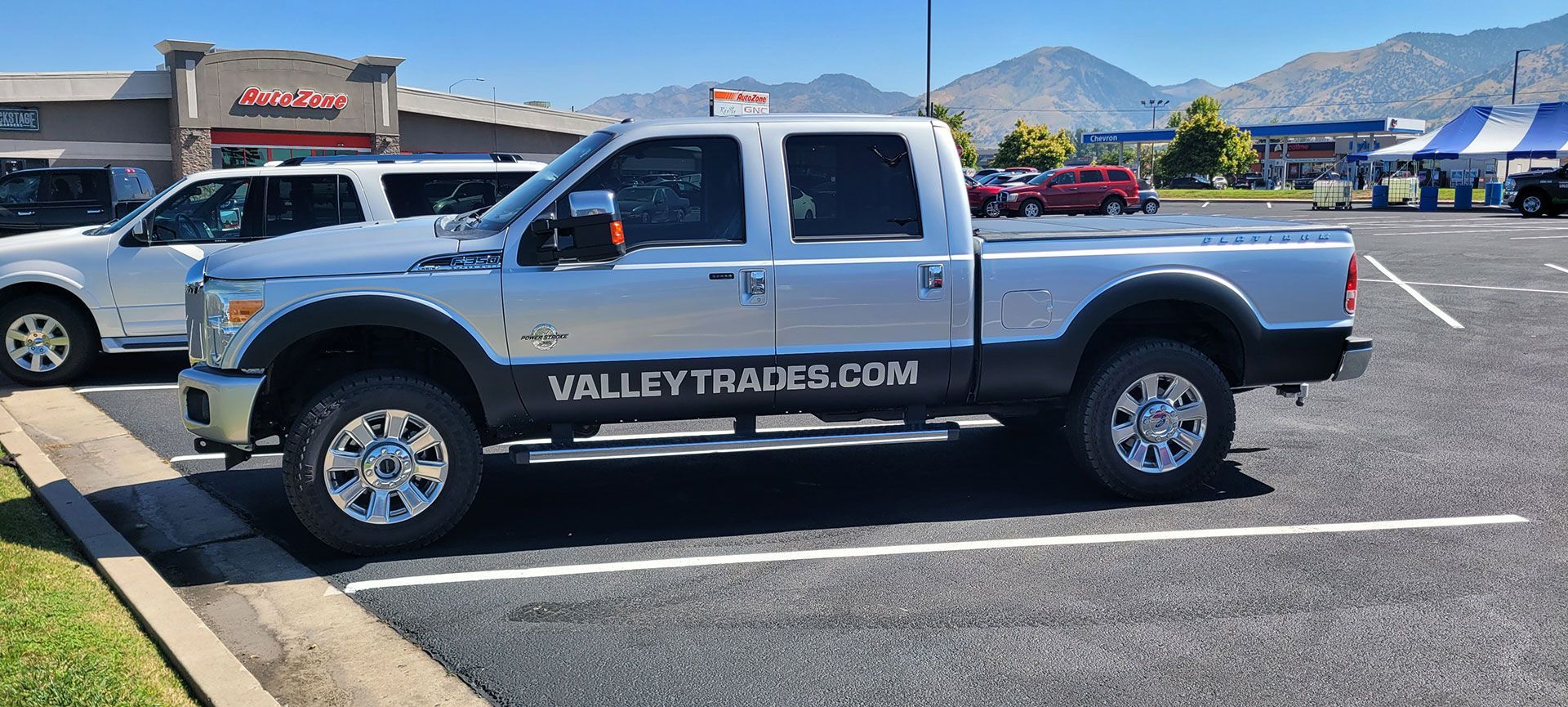 Silver pickup truck parked in a parking lot, the side reads 