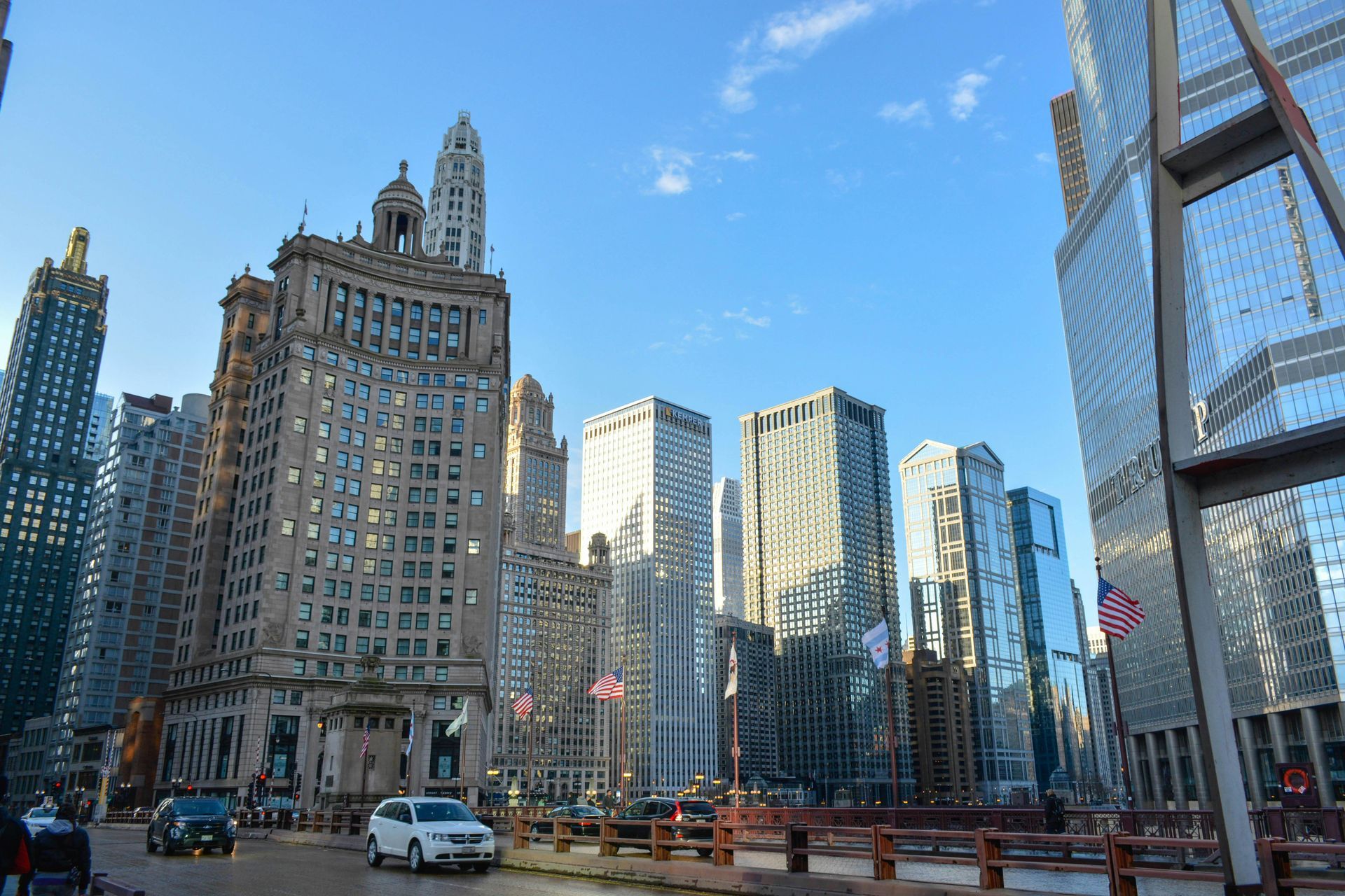 Chicago cityscape with tall buildings under a blue sky, including the Wrigley Building.
