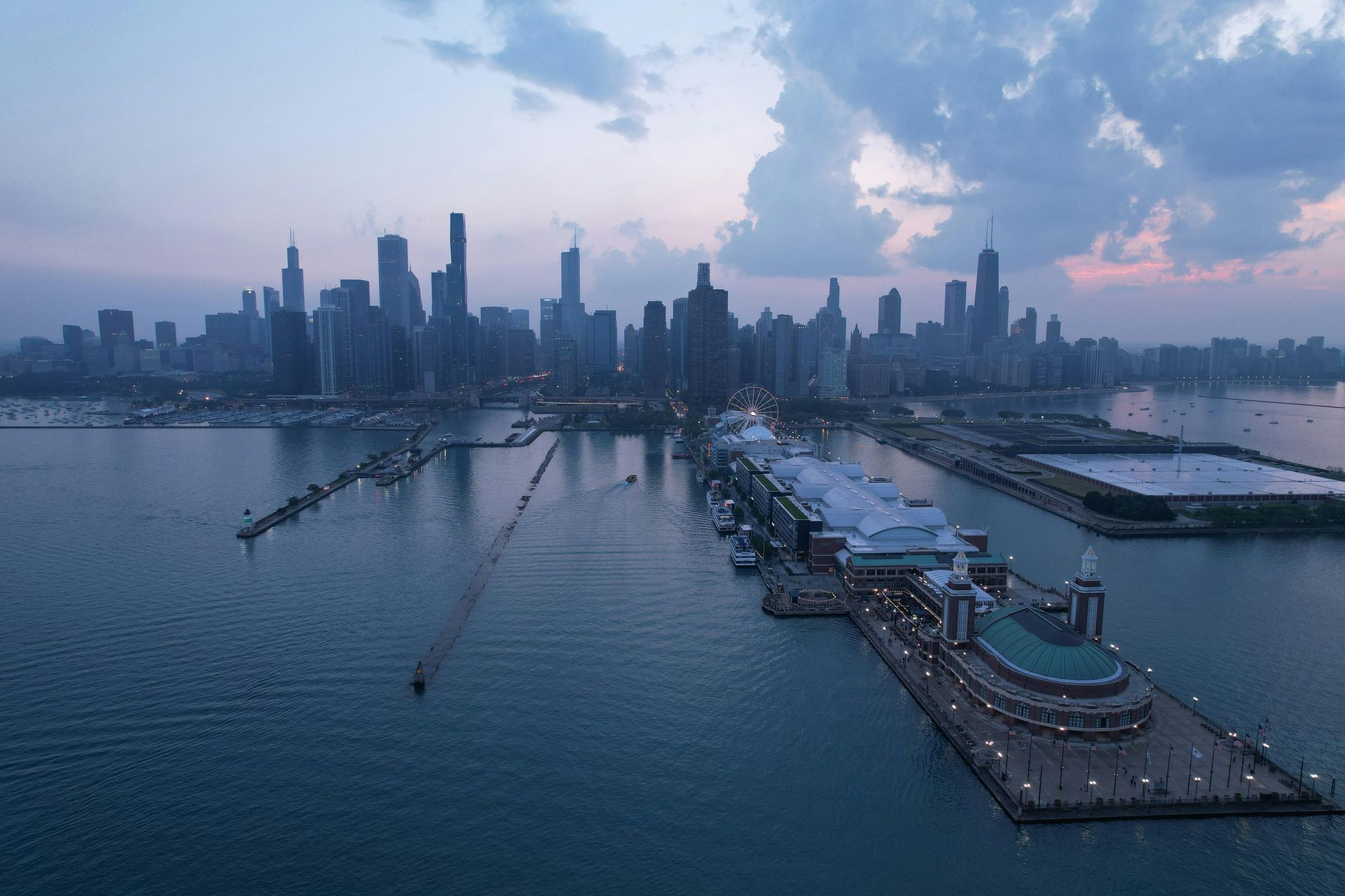 Chicago skyline at dusk over Lake Michigan, with Navy Pier in the foreground.