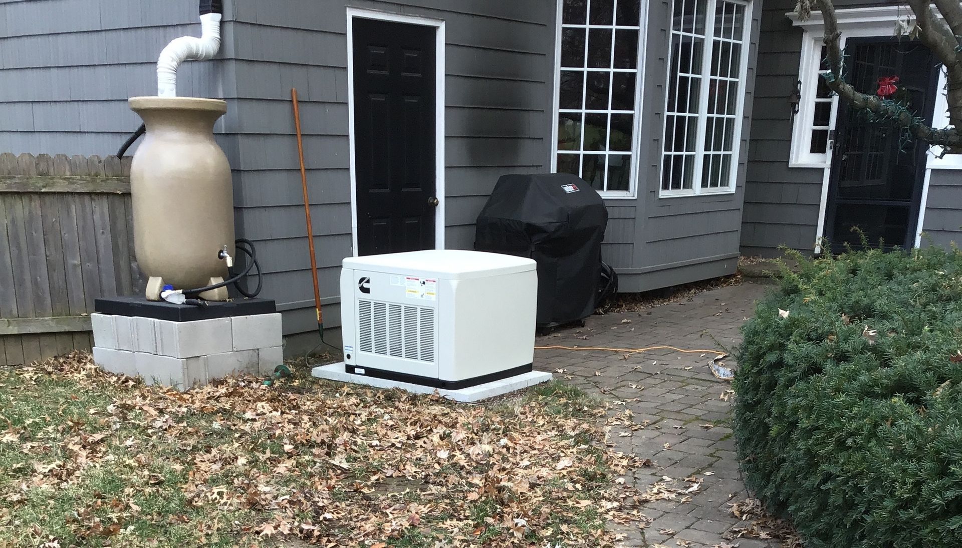 Exterior view with a rain barrel, AC unit, and house.