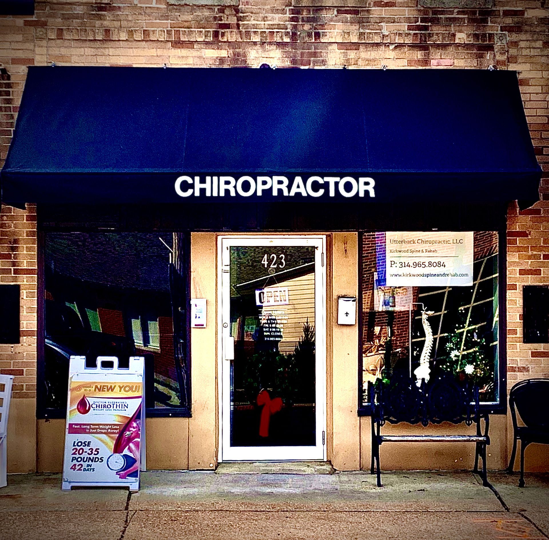 Chiropractor office with black awning. Door has address 