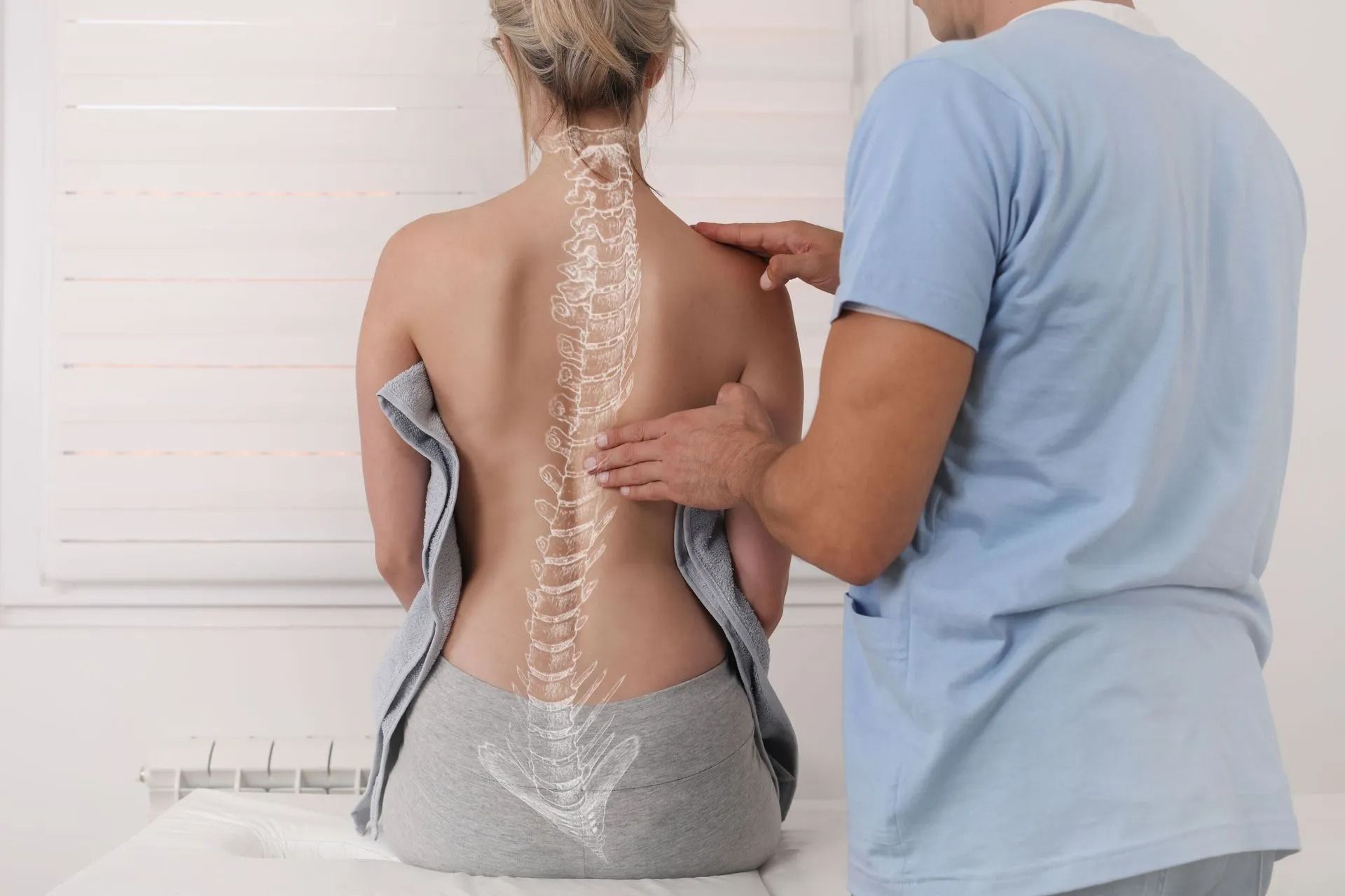 Physiotherapist examining a woman's spine. Bones are highlighted. Light blue shirt, white room.
