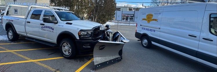 White pickup truck with snowplow parked next to a white van in a parking lot.