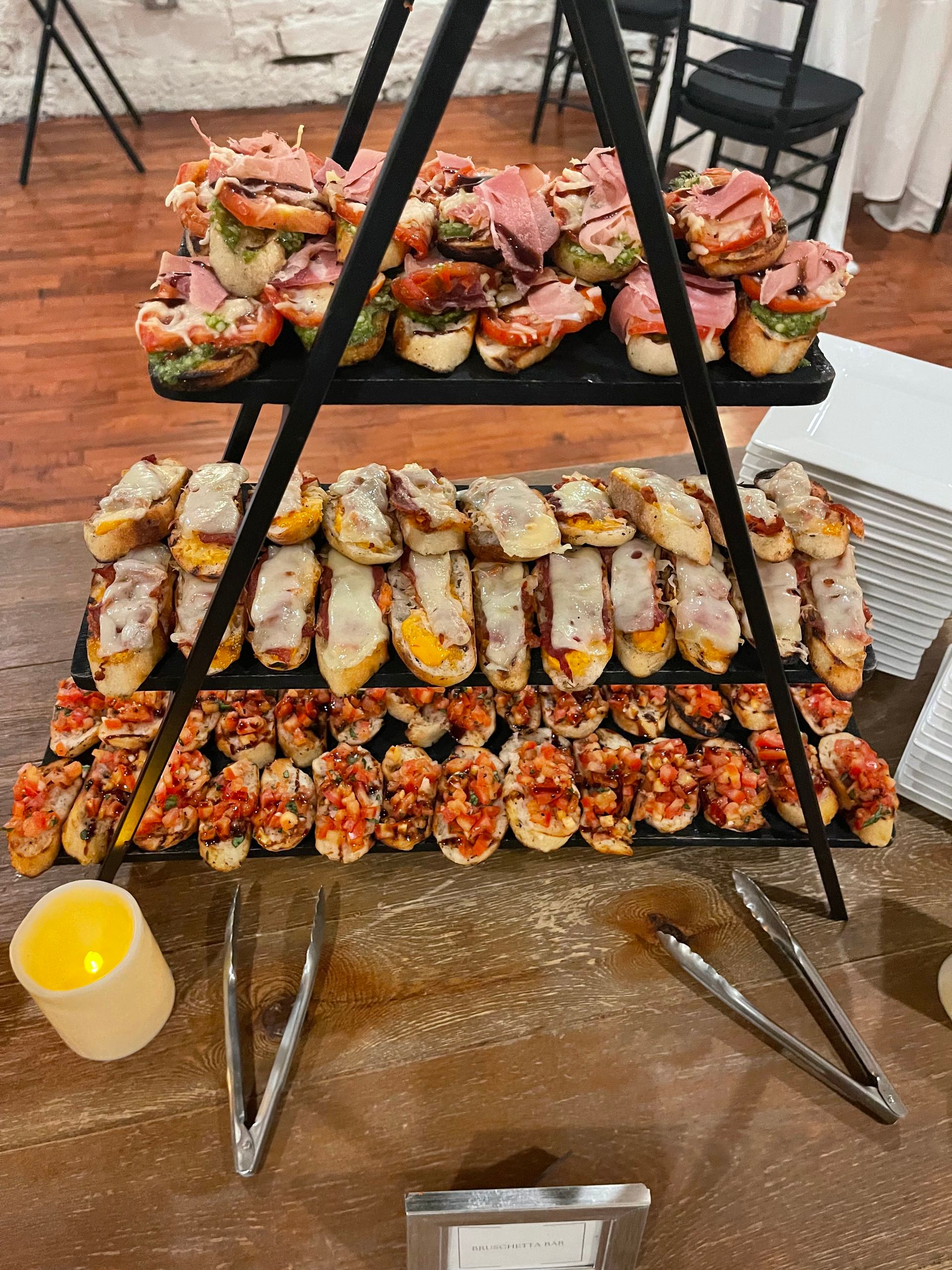 A table topped with a tray of food and tongs.