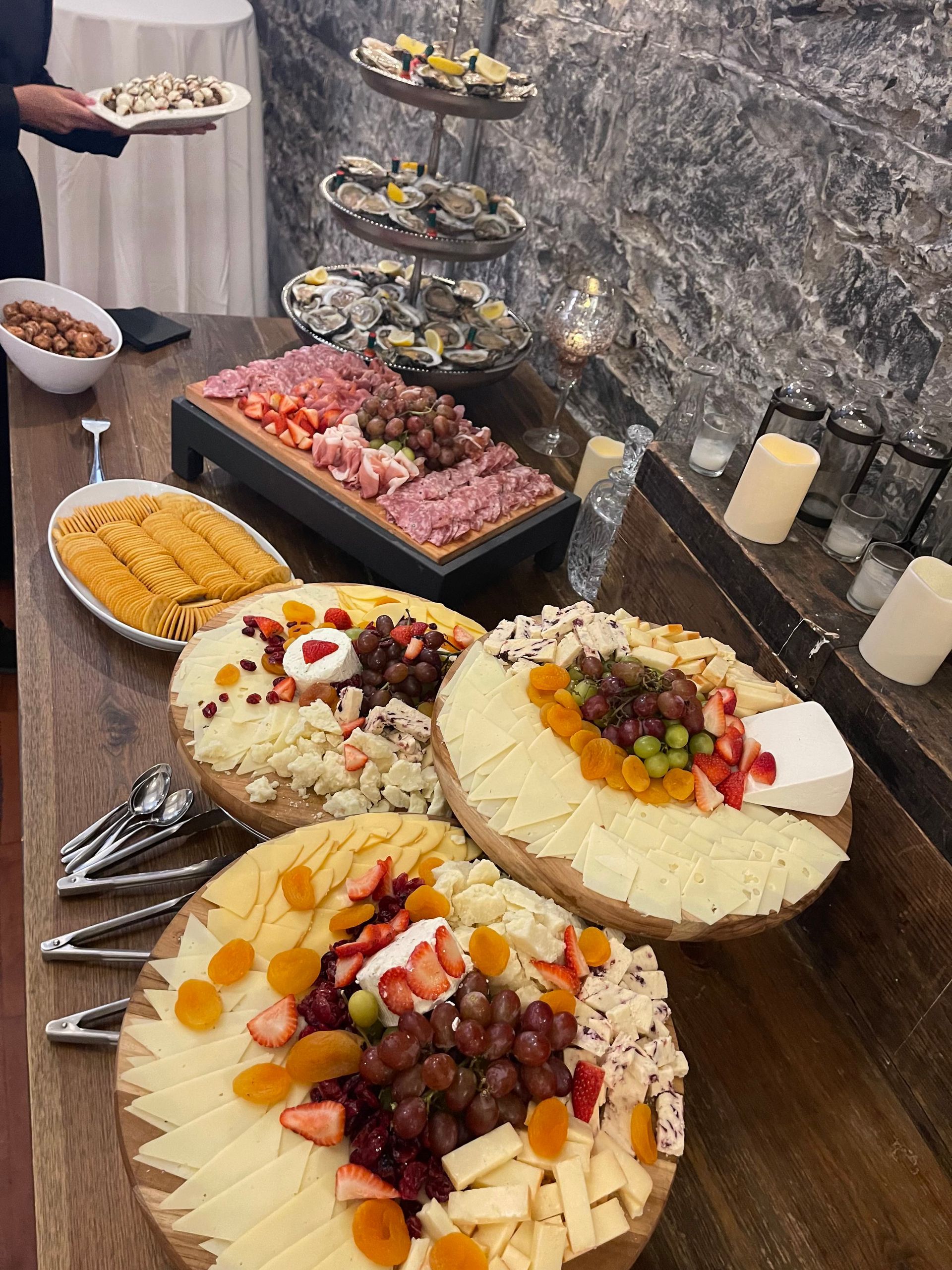 A wooden table topped with plates of food and candles.