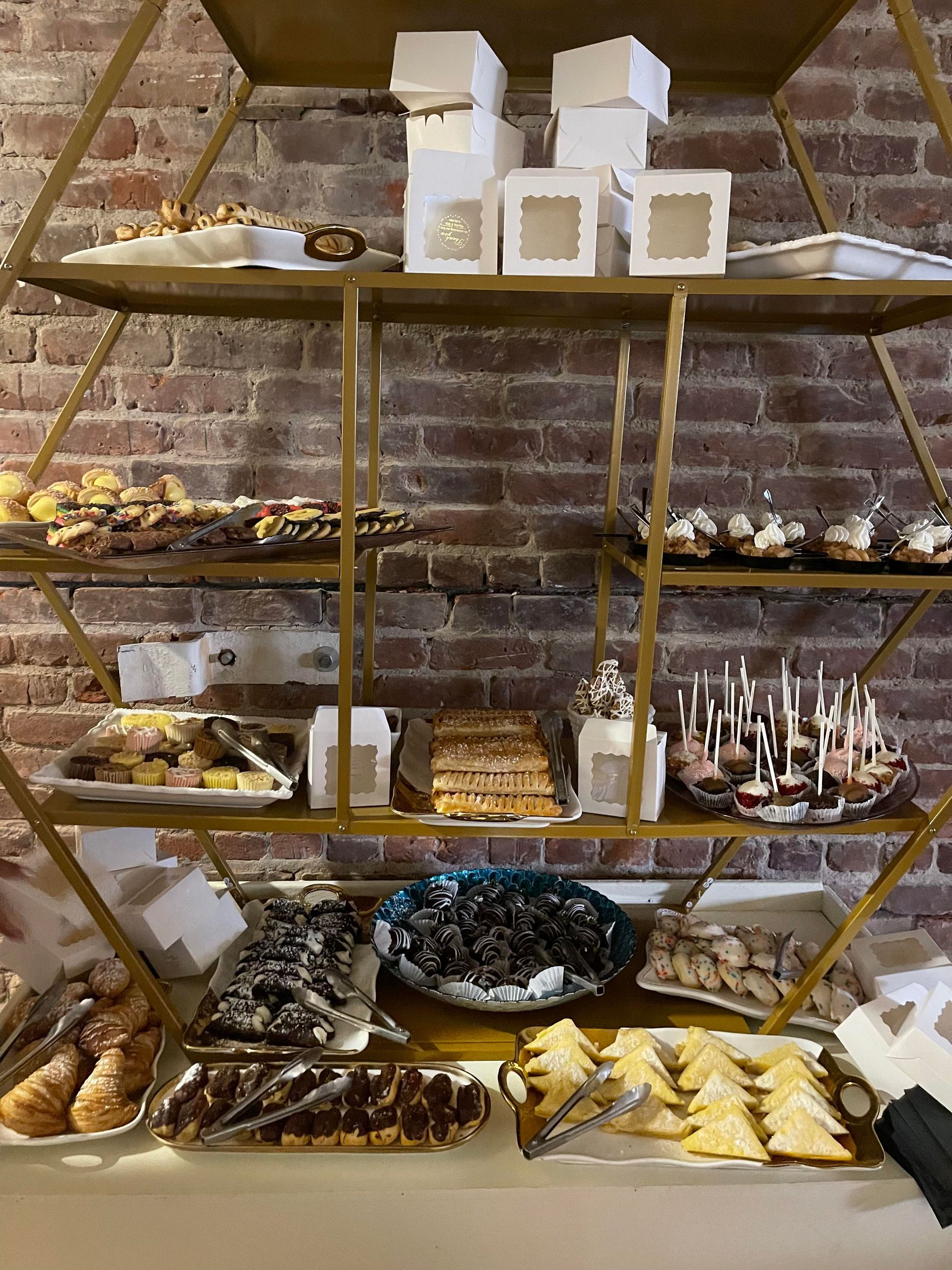 There are many different types of desserts on the shelves.