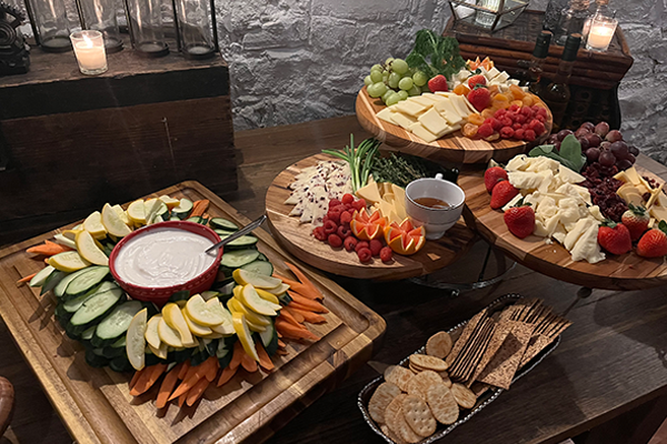 A wooden table topped with plates of fruits and vegetables.