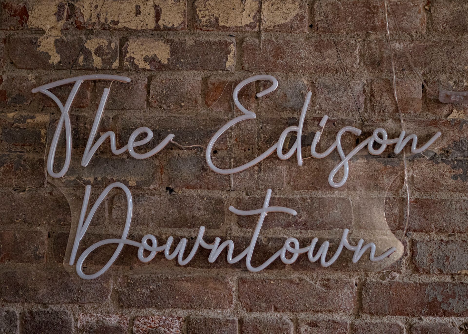 A brick wall with the words `` the edison downtown '' written on it.