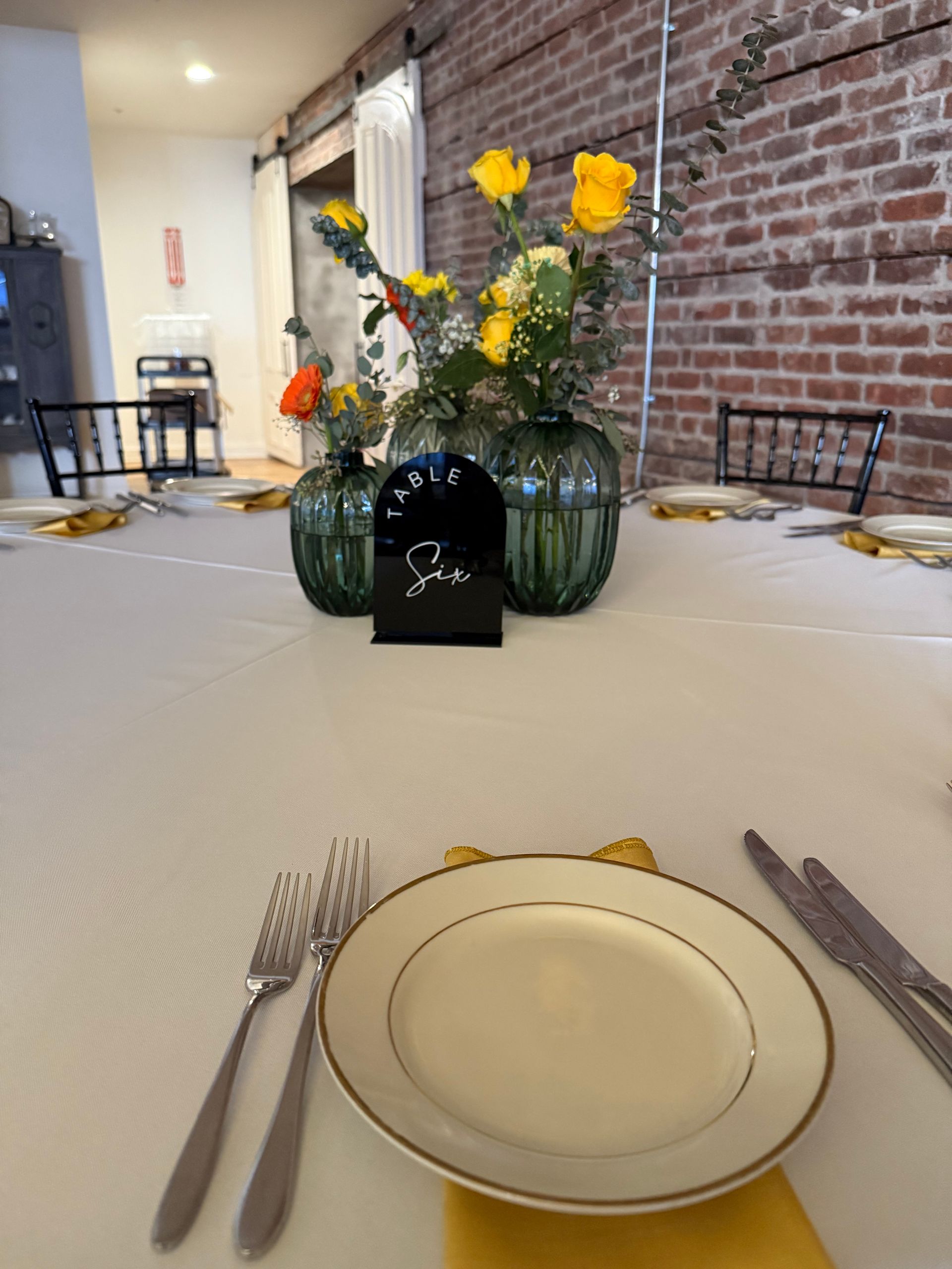 A table with plates utensils and flowers on it
