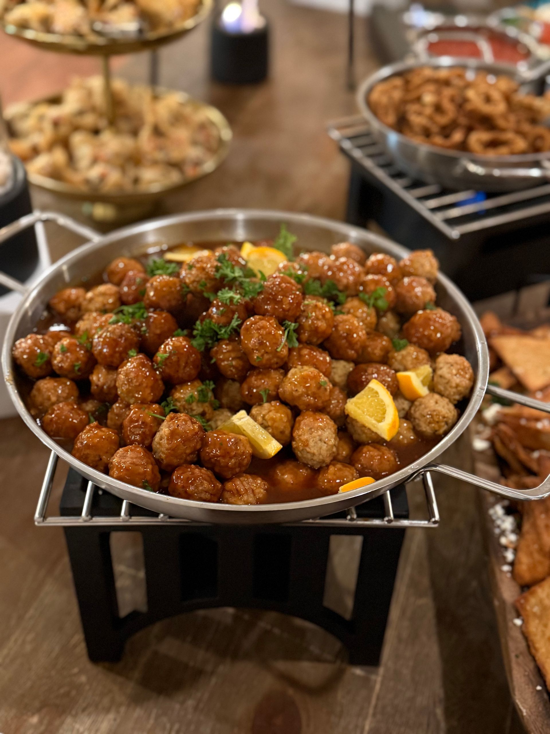 A pan filled with meatballs and lemon slices on a table.