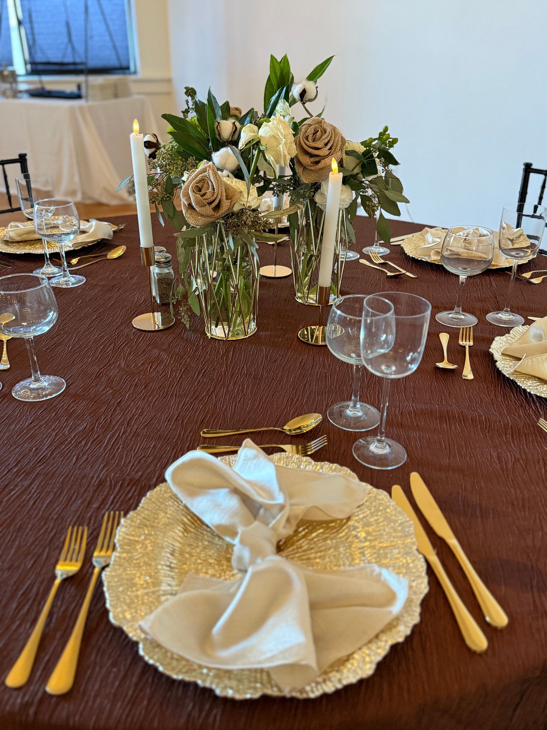 A table with plates , utensils , candles and flowers on it