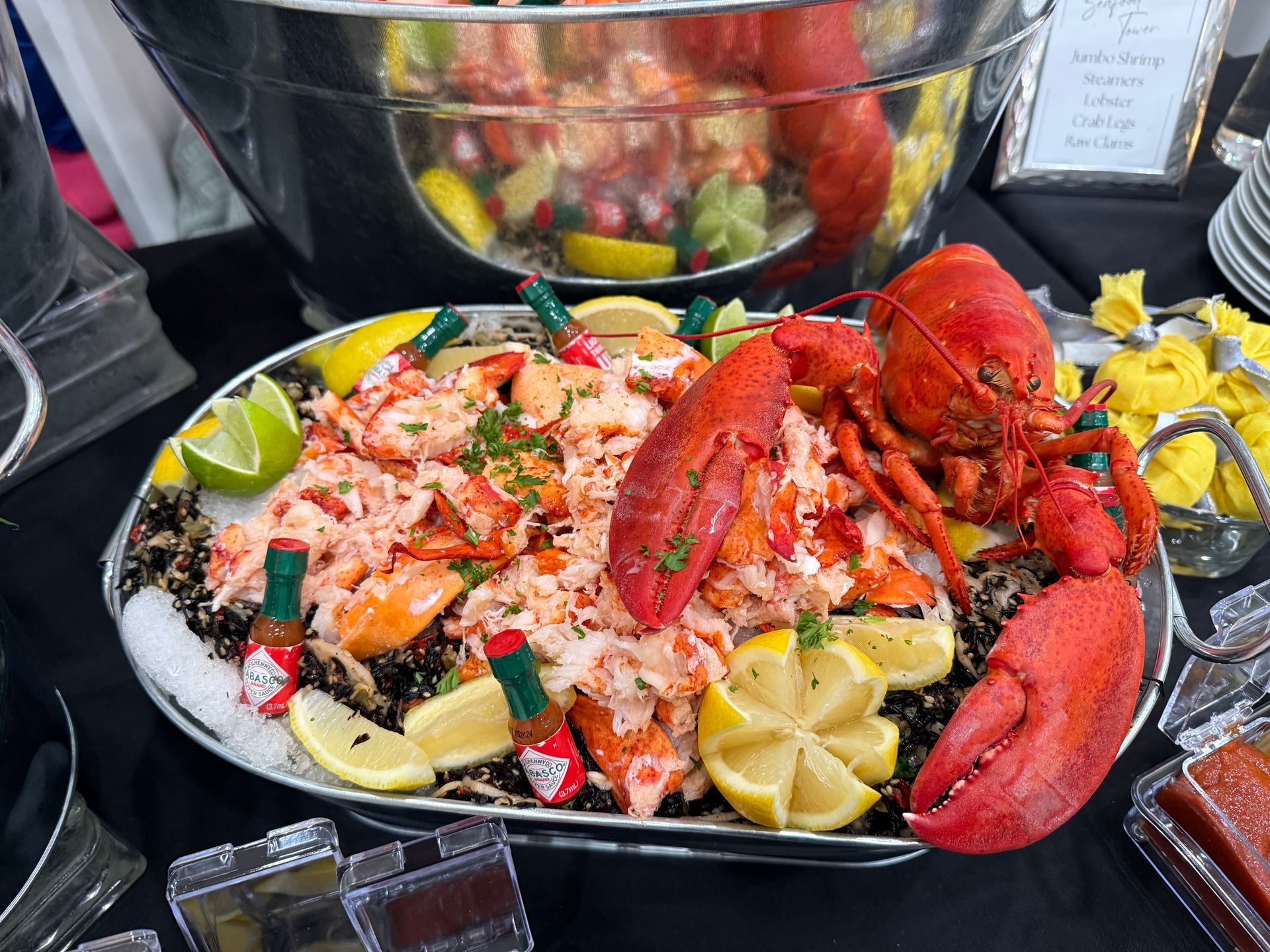 A large lobster is sitting on top of a plate of food on a table.