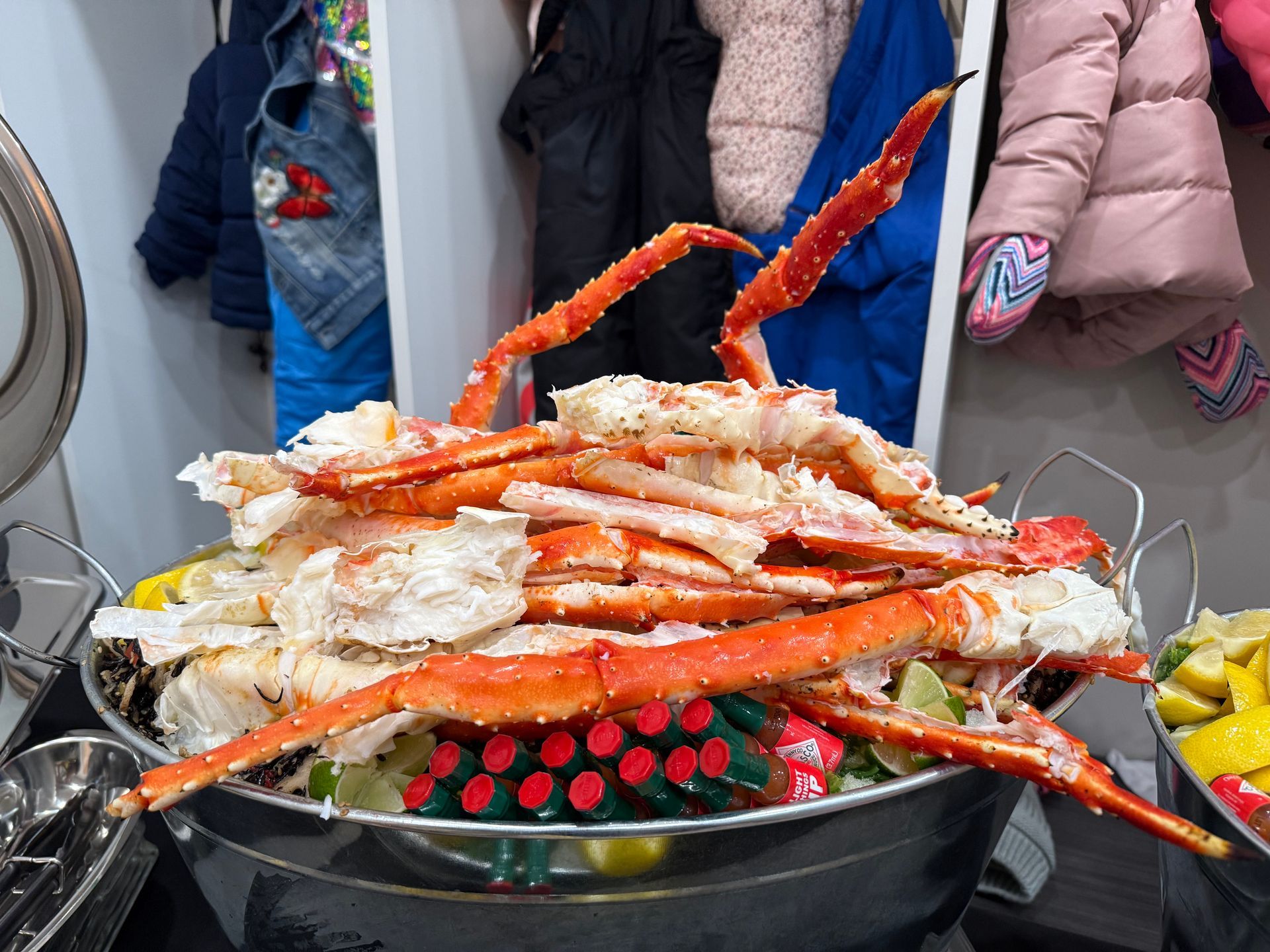 A large bucket of crab legs is sitting on a table.