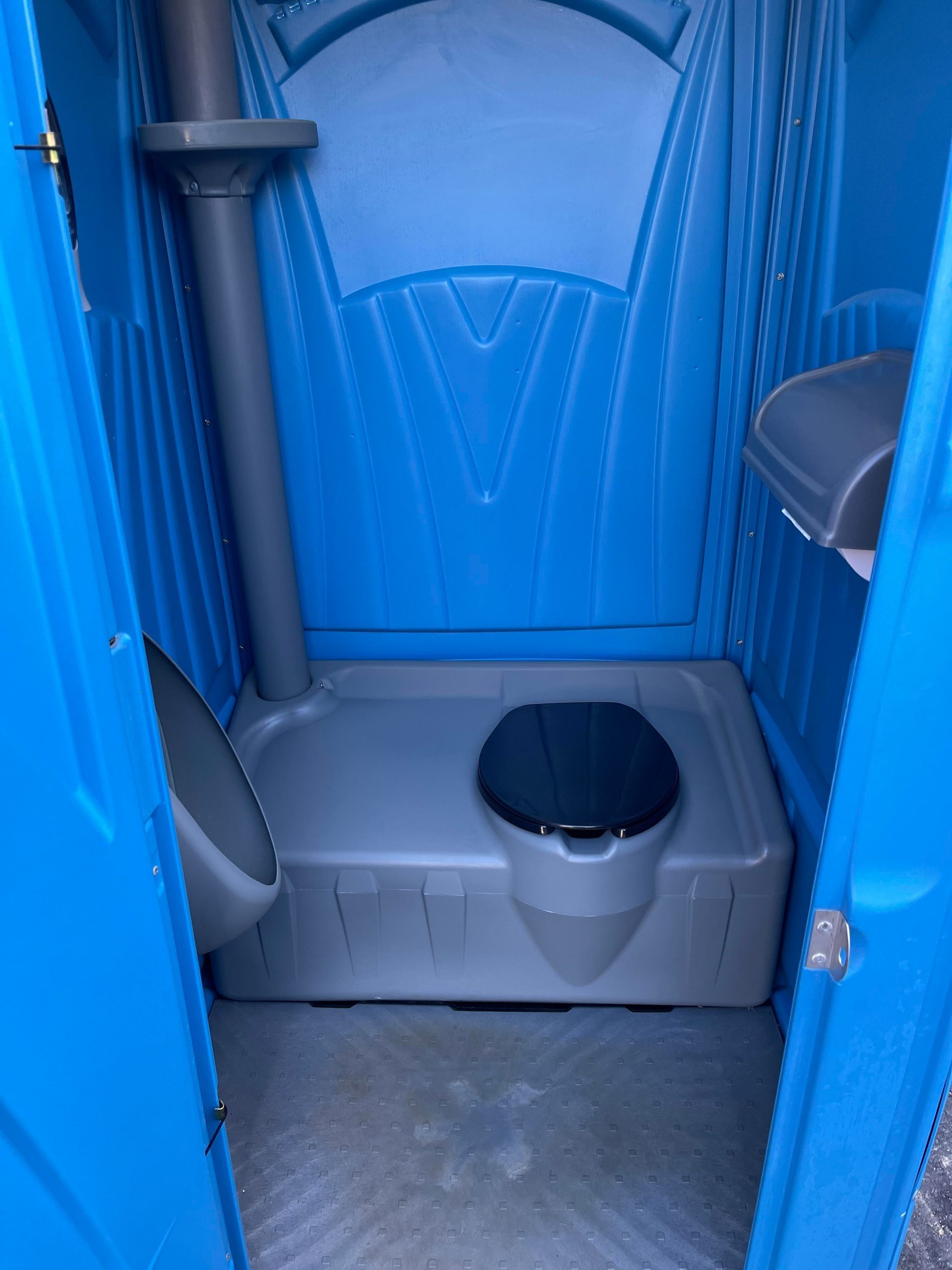 Blue portable toilet interior with open door and toilet seat visible