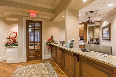 A dental office with a reception desk and a ceiling fan.